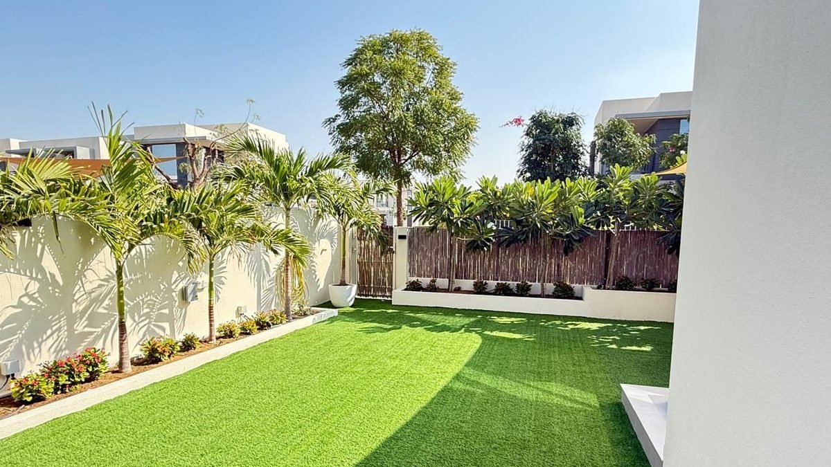 Landscaped Dubai villa garden with palms and planted borders